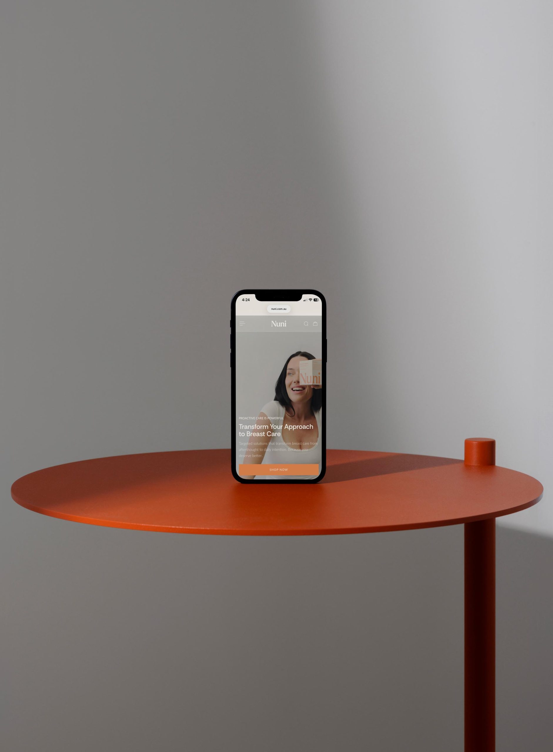 Hand holding phone displaying Nuni Wellness home page