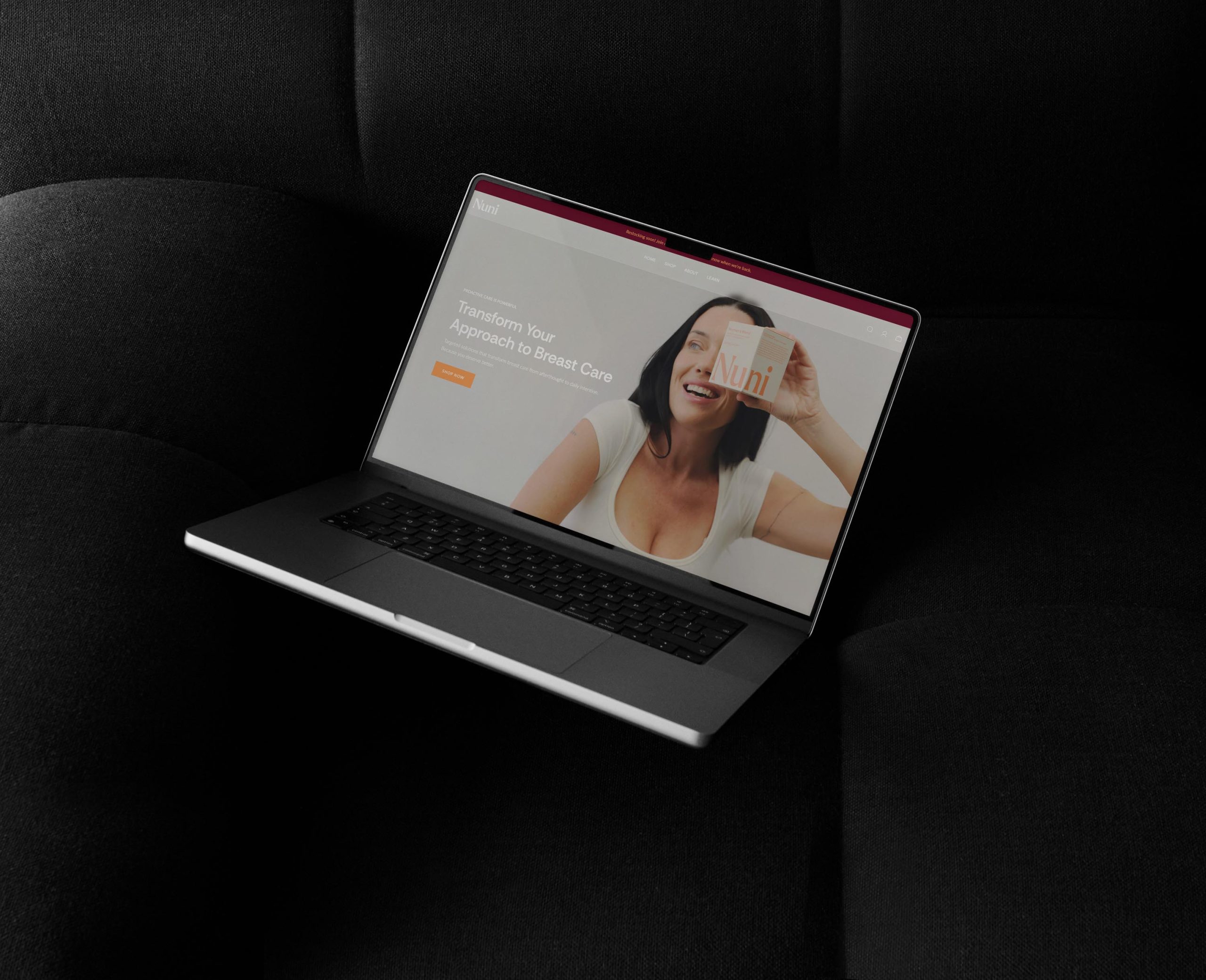 website design for Nuni Wellness. A laptop sitting on a couch displaying the Nuni home page
