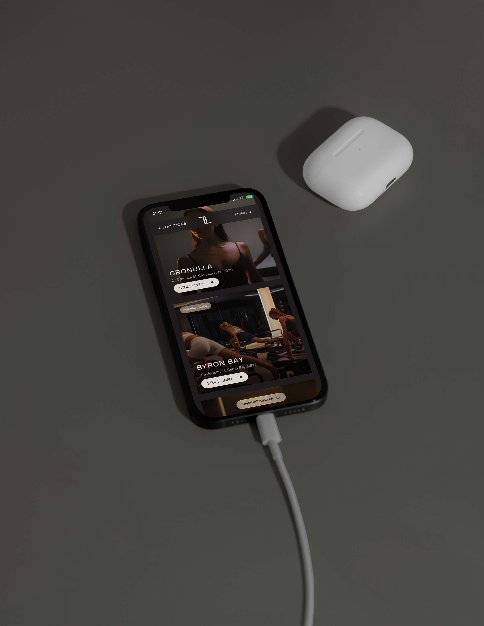 The Loft Pilates website shown on a mobile phone